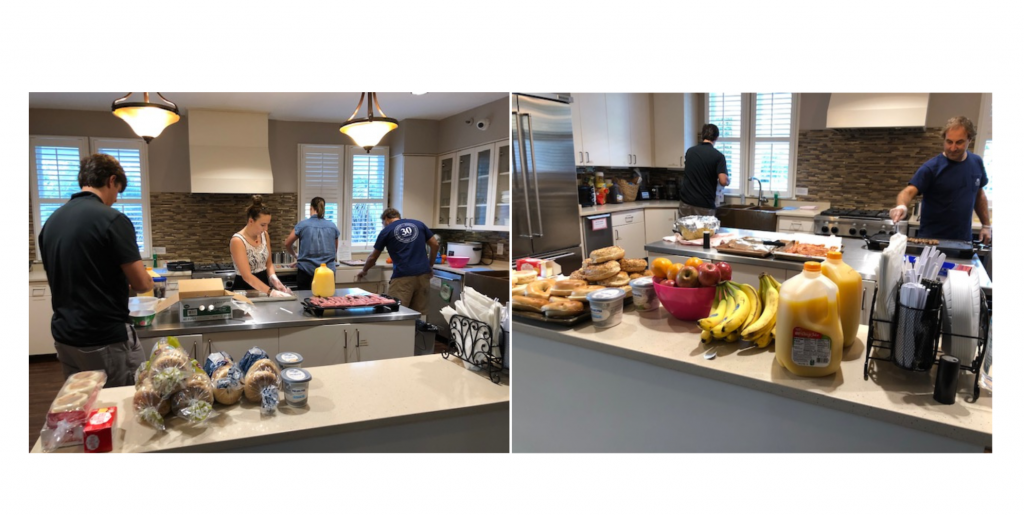 Employees preparing breakfast of eggs, bacon, bagels and fruit