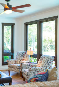 windows with 2 chairs and ceiling fan